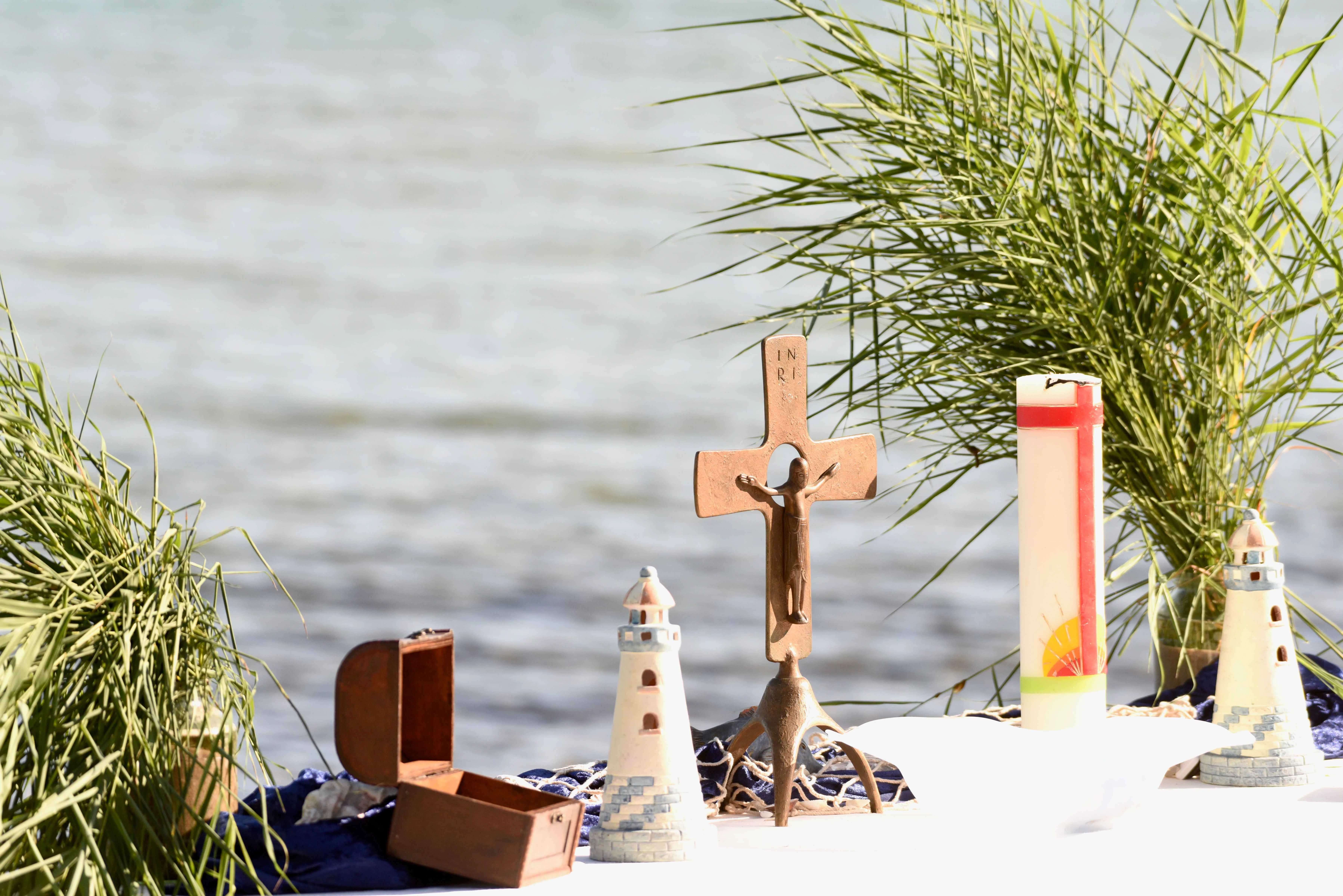 Strand mit Kerze, Karte und Kreuz